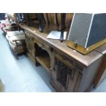 A LATE VICTORIAN CARVED OAK PEDESTAL SIDEBOARD, WITH CENTRE DRAWER OVER AN AN OPEN COMPARTMENT,