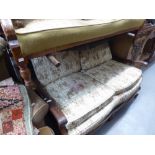 A CARVED MAHOGANY FRAMED BERGERE TWO SEATER SETTEE WITH SINGLE CANE PANELS, ON CLAW AND BALL FEET (