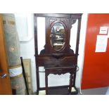 A VICTORIAN MAHOGANY HALL STAND, THE CENTRAL OVAL MIRROR OVER SHELF, CARVED DECORATION THROUGHOUT,