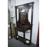 A VICTORIAN MAHOGANY HALL STAND, THE CENTRAL OVAL MIRROR OVER SHELF, CARVED DECORATION THROUGHOUT,