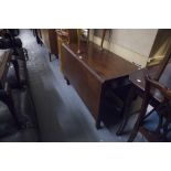 AN ANTIQUE MAHOGANY DROP LEAF DINING TABLE