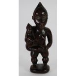 POSSIBLE YOMBE CARVED WOOD MATERNITY FIGURE, modelled standing, carrying a child at her side, her