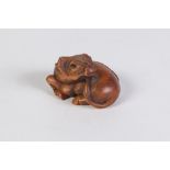 A JAPANESE WELL CARVED BOXWOOD NETSUKE OF A RECUMBENT WATER BUFFALO, with glass inset eyes, signed