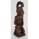 REPUBLIC OF CONGO CARVED WOOD MATERNITY FIGURE, modelled seated, feeding a baby from a large cup,