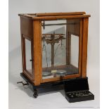 AN EARLY 20TH CENTURY L.OERTLING LTD London laboratory balance in glazed case, with a box of