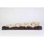 A JAPANESE MEIJI PERIOD CARVED IVORY TUSK SECTION of tapering form with five figures, a Shi-Shi
