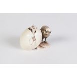 A JAPANESE WELL CARVED IVORY NETSUKE OF A CHICK BESIDE AN EGG FROM WHICH A FURTHER CHICK IS