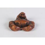 A JAPANESE WELL CARVED BOXWOOD NETSUKE OF A MONKEY BEHIND A CRAB, with glass inset eyes, signed with