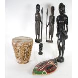 AFRICAN CARVED DARK WOOD FIGURE OF A WARRIOR, modelled standing holding an elliptical, painted