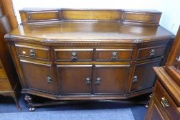 AN OAK SIDEBOARD WITH SLIGHT DOUBLE RETURN SHAPED FRONT, LOW BACK FITTED WITH TWO SHALLOW ANGLED