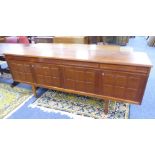 1970'S TEAK WOOD LONG, LOW SIDEBOARD WITH FOUR FRIEZE DRAWERS OVER FOUR EMBOSSED PANEL DOORS