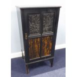 AN EDWARDIAN EBONISED MUSIC CABINET WITH FRAMED EMBOSSED AND COROMANDEL WOOD PANELS, ON SQUARE