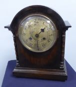 A MANTEL CLOCK WITH 8 DAY STRIKING MOVEMENT AND SILVERED CIRCULAR DIAL, IN OAK CASE WITH LOW DOME
