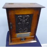 A PRESENTATION SMOKER'S OAK CABINET ENCLOSED BY FRAMED DOOR WITH EMBOSSED COPPER PANEL, DRAWERS