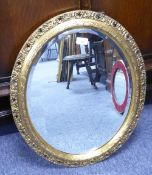 A MIRROR WITH BEVELLED OVAL PLATE, 20" X 15", IN GILT GESSO FRAME WITH HALF ROUND INNER RIM AND OPEN