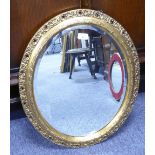 A MIRROR WITH BEVELLED OVAL PLATE, 20" X 15", IN GILT GESSO FRAME WITH HALF ROUND INNER RIM AND OPEN