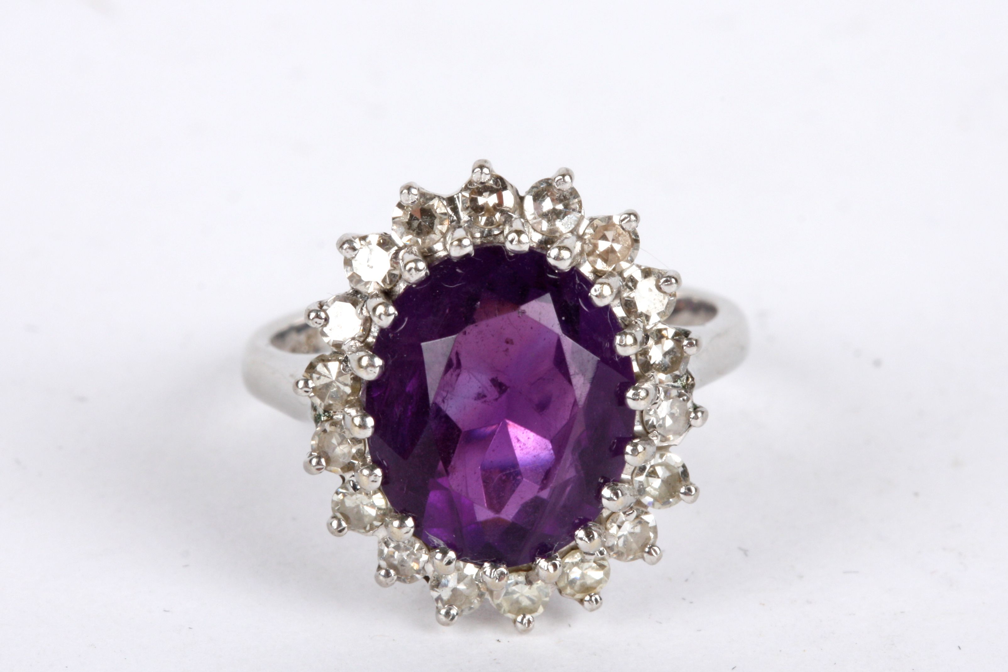 A Continental large oval amethyst and diamond cluster cocktail ring the central amethyst of pleasing