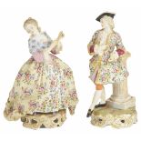 A pair of Continental porcelain figurines, early 20th century the lady holding a fan dressed in a