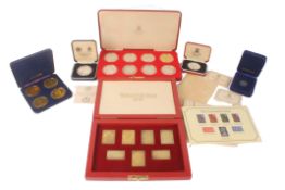 A cased set of seven silver gilt Coronation Issue replica stamps ingots, each with serrated edge and