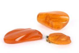 Three large unmounted pieces of butterscotch amber all of differing shapes and sizes, mainly