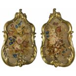 A pair of early 19th Century gilt framed chenille work panels of floral design in ornate gilt wood