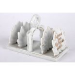 A porcelain toast rack 'A Present from The Crystal Palace' modelled as leaves highlighted in gilt