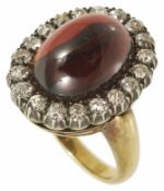 An Early Victorian cabochon garnet and diamond set oval cluster ring the large central garnet set