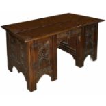 An oak carved knee hole desk, late 19th century of rectangular form with central drawer flanked by