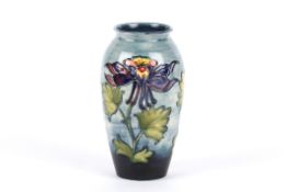 A William Moorcroft tube lined vase, 20th century of baluster shape with bluish ground and columbine