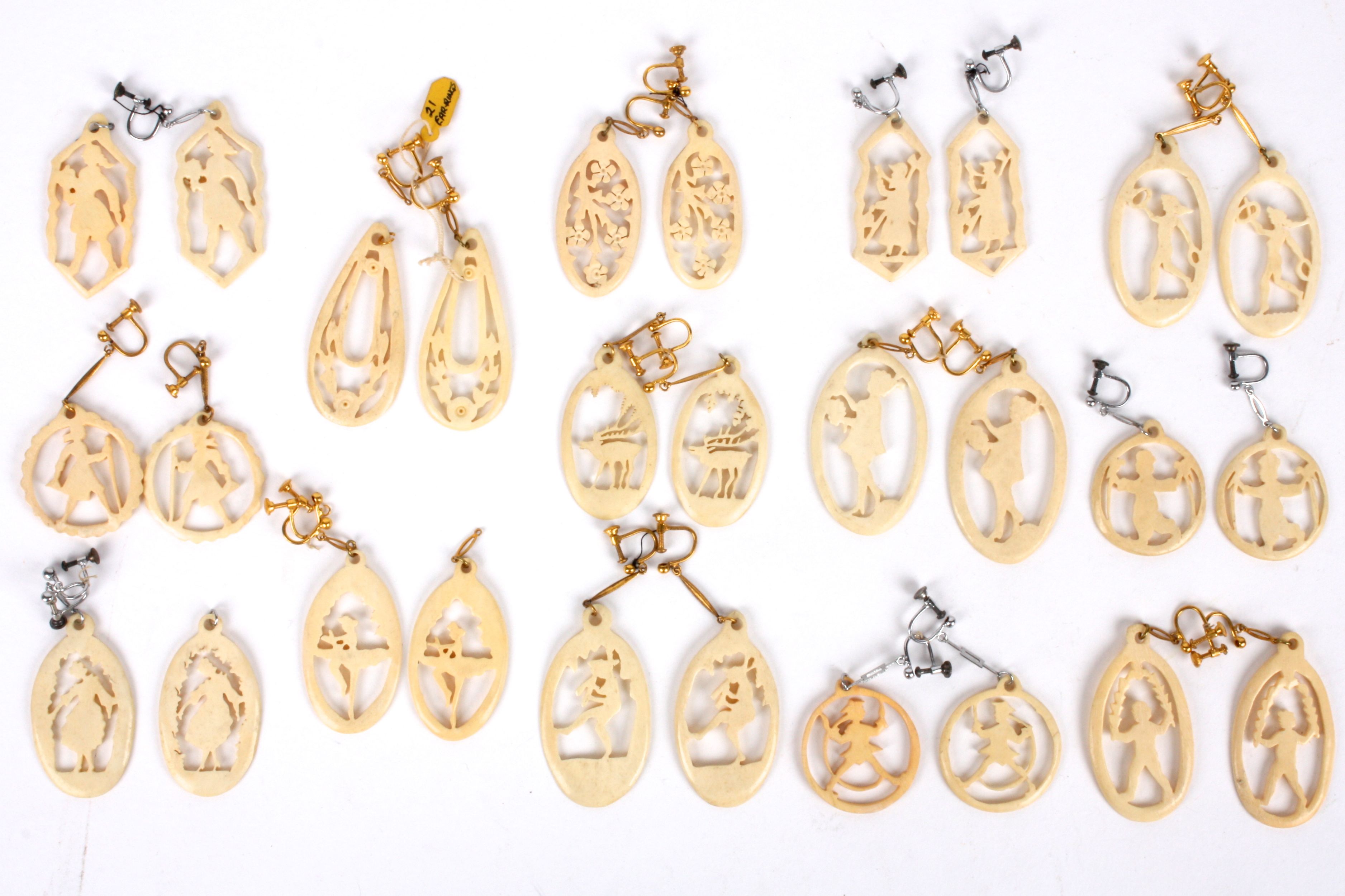 A collection of 1920's pierced and carved ivory silhouette pendant drops paired and with ear drop