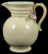 A Clarice Cliff cream ground jug, the ribbed neck above a bulbous body with circular foot ring and