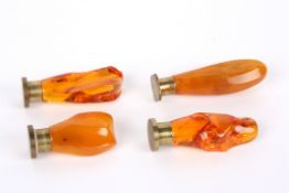 Four similar amber seals comprising two seals with butterscotch amber handles, and two with honey