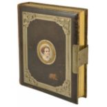 An interesting leather bound Victorian photograph album with vignette to the front with painted