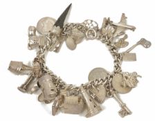 A heavy silver charm bracelet hung with a good selection of charms, some articulated and including