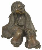 A 19th century Japanese bronze figure of a seated Lohan the figure leaning back on one hand with