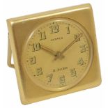 A 1950s gilt metal 8-day travel clock by Hermes with easel stand, and dial with Arabic numerals,