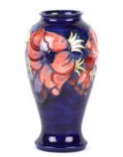 A William Moorcroft tube lined vase, 20th century of tall proportions, baluster shaped with sprays