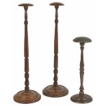 A pair of Georgian walnut and mahogany wig stands of turned columnar form with domed circular top,