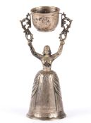 A Continental silver wager cup, 19th century modelled as a maiden standing with her arms above her