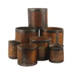 A collection of seven 19th and early 20th century wooden grain measures, each with metal banding,