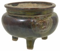 An early 20th Century Chinese style pottery three legged Ding with overall green and brown drip