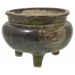 An early 20th Century Chinese style pottery three legged Ding with overall green and brown drip