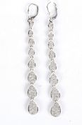 A pair of 18ct contemporary pave set diamond drop earrings of graduated tear drop design, white