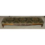A Victorian mahogany footstool, of long proportions with upholstered upper section above foliate