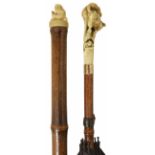 Two Victorian parasols with ivory handles the first with wooden shaft and black fabric and carved