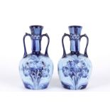 A pair of James MacIntyre William Moorcroft Florian ware tube lined vases, circa 1905 the narrow