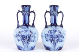 A pair of James MacIntyre William Moorcroft Florian ware tube lined vases, circa 1905 the narrow