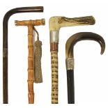 Three late 19th/early 20th century walking canes and later umbrella including a walking cane with