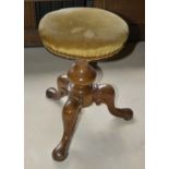A Victorian walnut piano stool, the upholstered circular seat above bulbous support with three s-