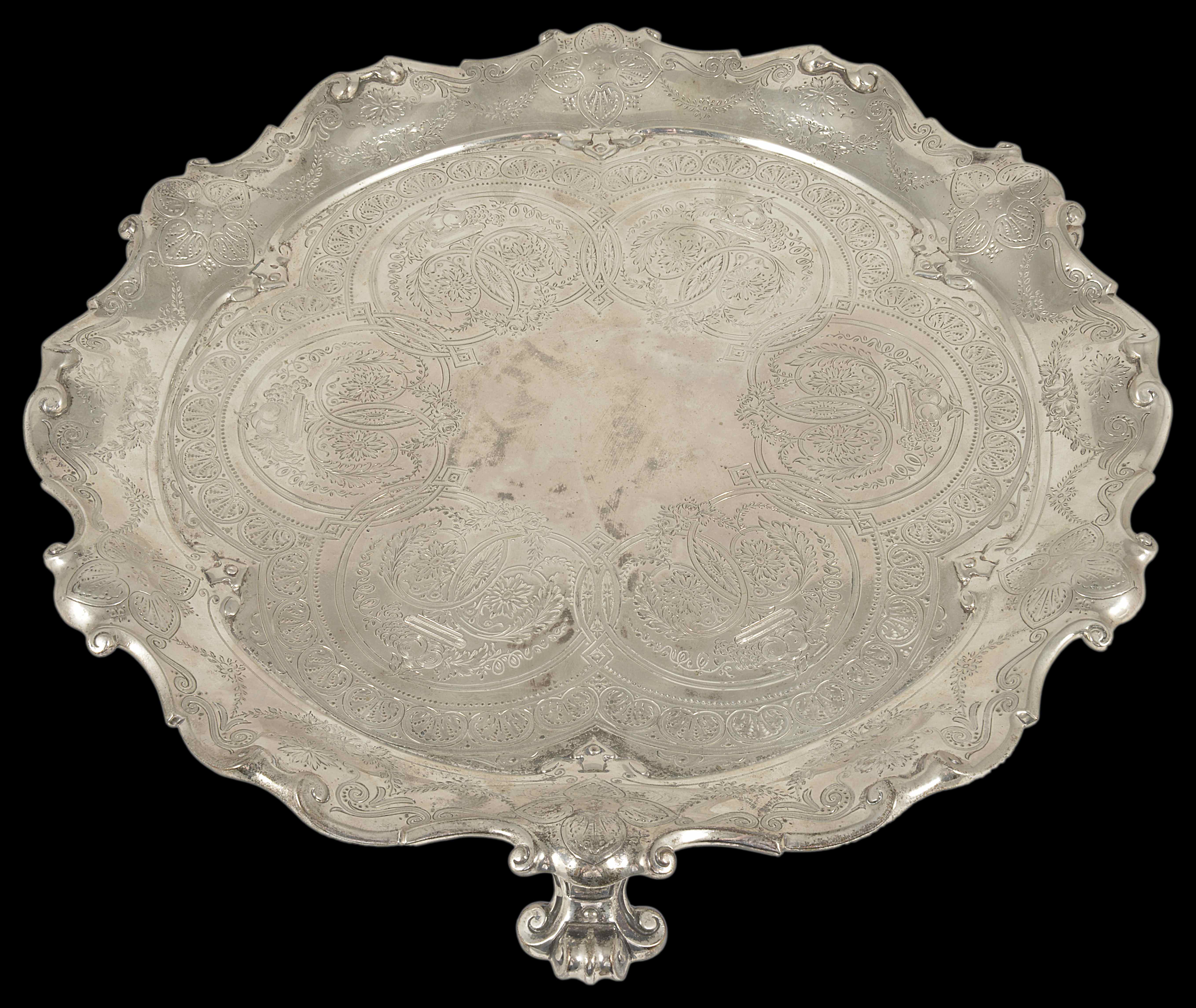 A Victorian silver tray, London 1895 the scrolled edge raised upon three scrolled supports, the